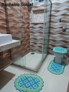 ein Bad mit einer Dusche, einem WC und Matten in der Unterkunft CASA DE TEMPORADA DE FÉRIAS in Santa Cruz Cabrália