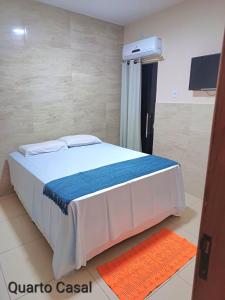een slaapkamer met een bed met een blauw en wit dekbed bij CASA DE TEMPORADA DE FÉRIAS in Santa Cruz Cabrália