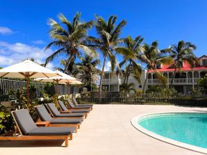 una fila de tumbonas junto a una piscina en Orient bay - Apartment Oceanview - Alamanda beach residence, en Orient Bay