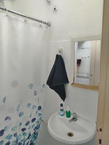 La salle de bains est pourvue d'un lavabo, d'une douche et d'un miroir. dans l'établissement AgattaGuia&Hospeda Lapa Rio 1103, à Rio de Janeiro