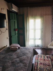um quarto com uma cama com uma porta verde e uma janela em Şirince leylak ev pansiyon em Selçuk