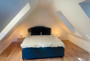 a bedroom with a blue bed in a attic at Apartament nad jeziorem in Rydzówka