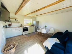 a living room with a blue couch and a table at Apartament nad jeziorem in Rydzówka +6 photos