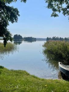 łódź siedząca na brzegu jeziora w obiekcie Apartament nad jeziorem w mieście Rydzówka