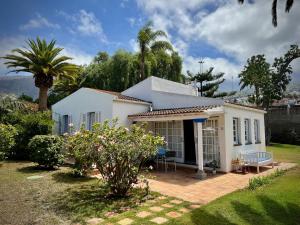 a white house with a patio and a palm tree at Villa Finca El Drago in La Orotava