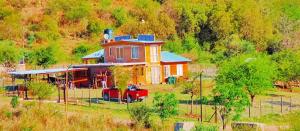 uma casa com um camião vermelho estacionado em frente dela em Chalet de Montaña Luna de Valle em Valle Hermoso