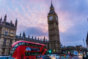a red double decker bus in front of big ben at (R0)2 Bedroom Flat in Zone 2 Lnd in London