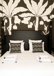 ein Schlafzimmer mit einem Bett und einer schwarz-weißen Wand in der Unterkunft Riad Pompon in Marrakesch