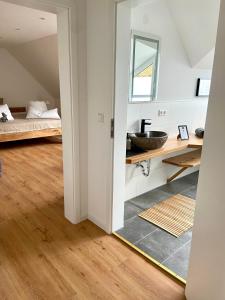 baño con lavabo y 1 cama en una habitación en Harzpur Lodge - Pure Entspannung in purer Natur, en Hahnenklee-Bockswiese