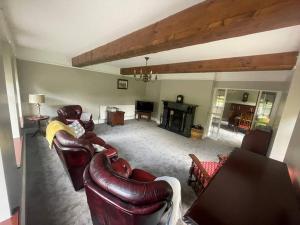 a living room with leather furniture and a fireplace at Gortaclare Lodge in Beragh