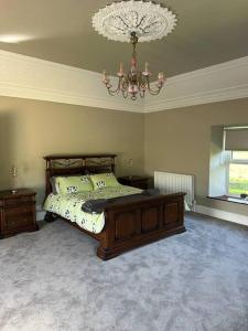 a bedroom with a bed and a chandelier at Gortaclare Lodge 