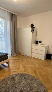 a living room with a wooden floor and a white cabinet at Warszawa Krucza Pokoje in Warsaw