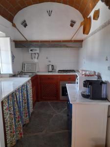 uma cozinha com armários vermelhos e um forno de fogão branco em Monte do Ribeiro Baço - Monsaraz em Monsaraz