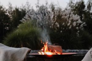 a person is sitting around a fire in a grill at Siedlisko Nad Miedwiem in Stargard