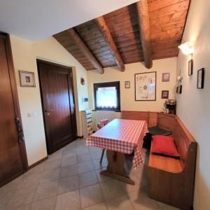 波斯科的住宿－Cinque Abeti Agrialloggio Mountain Lake Iseo Hospitality，一间用餐室,配有一张桌子和一张红白色的桌布