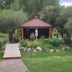 a small gazebo in a garden with a wooden bridge at BuffaloPeaks Lodge in Buena Vista