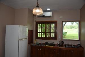 a kitchen with a white refrigerator and a window at Beer Hotel Iguazú in Puerto Iguazú