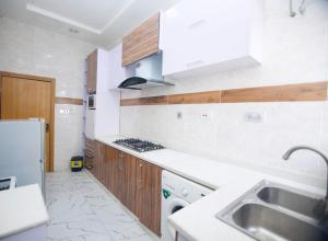 a kitchen with a sink and a stove top oven at Oasis Villa Lekki in Lekki