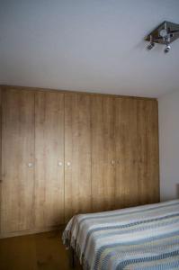 a bedroom with a bed and a wooden wall at Moderne 2-Zimmer-Wohnung in Albinen mit Aussicht in Albinen