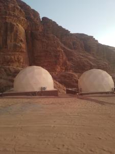 two domes in the desert near a mountain at Wadi rum desert sky in Wadi Rum +98 photos