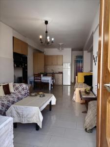 a living room with two couches and a kitchen at PERGAMOS APARTMENTS in Mytilini