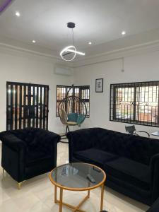 una sala de estar con 2 sofás negros y una mesa. en Chic-log, en Agbato