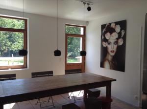 una sala da pranzo con tavolo e un dipinto sul muro di Manoir au Bois a Kasteelbrakel