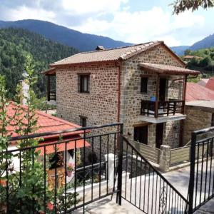 a house in the mountains with a balcony at Fairytale Stone House in Karpenision