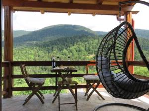 a rattan chair sitting on a porch with a table at Fairytale Stone House in Karpenisi