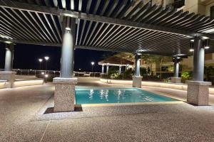 una piscina en medio de un edificio por la noche en Kenyalang Riverine Diamond Resort Homestay, en Kuching