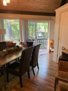 a dining room with a table and chairs and a porch at Round Cabin - 5 Min to Bedford PA - Deck - Hike- Golf in Bedford