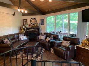 a living room with leather couches and a fireplace at Round Cabin - 5 Min to Bedford PA - Deck - Hike- Golf in Bedford