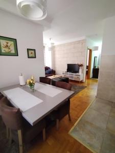 sala de estar con mesa, sillas y sofá en Zlatiborski Konaci-Apartman Maletic en Zlatibor