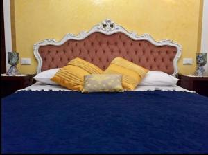 ein Schlafzimmer mit einem blauen Bett und gelben Kissen in der Unterkunft CA' DI LUNA VENEZIA in Venedig