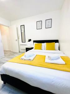 a bedroom with a large bed with yellow and white pillows at Private Studio Flat in City 1160 in London