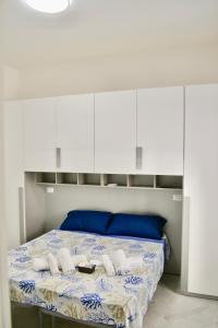 - une chambre avec un lit et des armoires blanches dans l'établissement ROMA LUXURY House Colosseo, à Rome