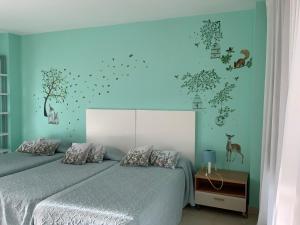 Schlafzimmer mit einem Bett mit blauer Wand in der Unterkunft Nacaren Cullera in Cullera