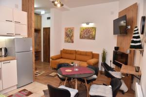 ein Wohnzimmer mit einem Sofa, einem Tisch und Stühlen in der Unterkunft Start Apartments LUX KOPAONIK in Kopaonik