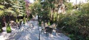 une rangée de chaises et de tables dans un jardin dans l'établissement Apartamenty Comfort, à Gniezno
