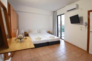 a hotel room with a bed and a table with a glass at Marnin Apartments in Rhodes Town