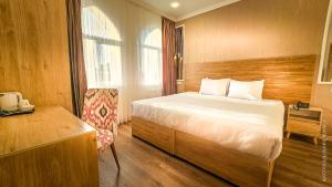 a bedroom with a bed and a wooden wall at Hotel Bankir Khiva in Khiva