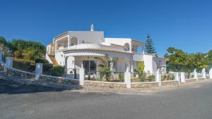 uma casa branca com uma cerca à frente. em Casa SP- Villa with heated pool near Vilamoura, Vale do Lobo em Quarteira
