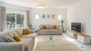 uma sala de estar com dois sofás e uma televisão em Casa SP- Villa with heated pool near Vilamoura, Vale do Lobo em Quarteira