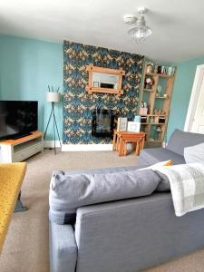 a living room with a couch and a tv at Driftwood Apartment in Saltburn-by-the-Sea