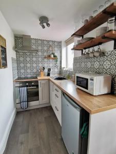 a kitchen with a counter top with a microwave at Driftwood Apartment in Saltburn-by-the-Sea