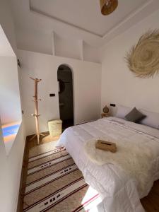 1 dormitorio con 1 cama y 1 cruz en la pared en Friendly Dades Lodge, 
