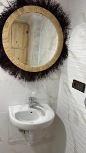 baño con lavabo y espejo en la pared en Friendly Dades Lodge, 