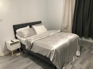 um quarto com uma cama com um edredão de prata em Rose Cottage em Tipton
