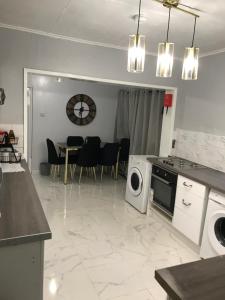 a kitchen and living room with a table and a washing machine at Rose Cottage in Tipton