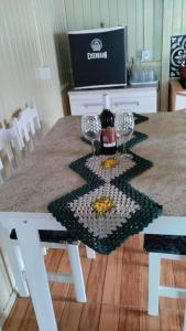 a table with two glasses and a bottle of wine at Pousada Flor da Serra in Urubici